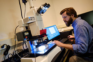 Student using microscope.