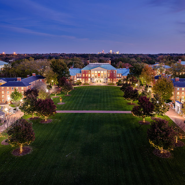 Reynolda Campus at night with Winston-Salem skyline in the background