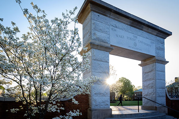 A student walks past the arch on Hearn Plaza on the campus of Wake Forest University on Wednesday, April 6, 2016.