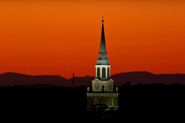 The bell tower of Wait Chapel rises in front of the sunset on the campus of Wake Forest University on Saturday, October 15, 2011.