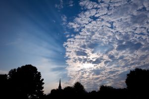 The bell tower of Wait Chapel is silhouetted against clouds and sky.