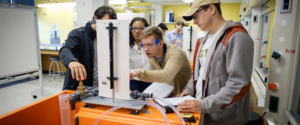 Wake Forest engineering students measure water pressure inside a pipe in a hydrodynamics lab at Wake Downtown
