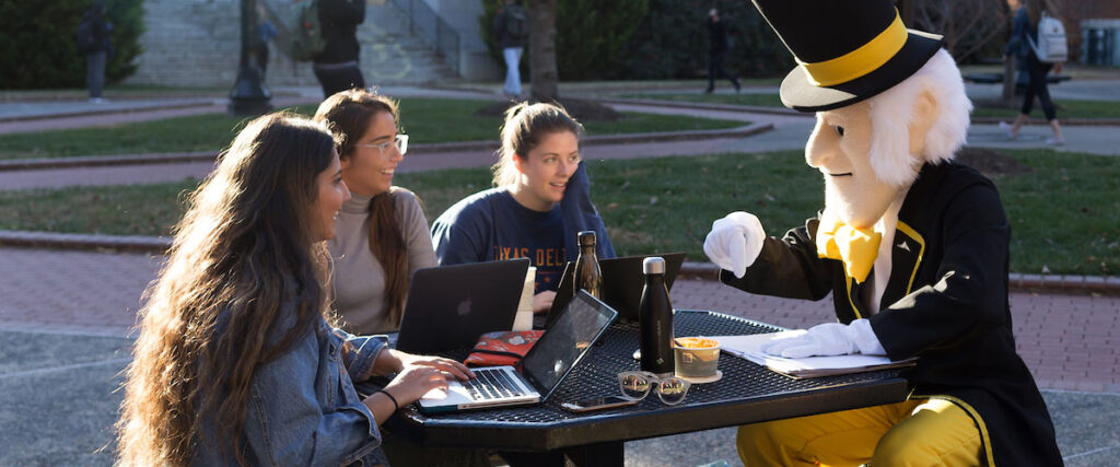 The Demon Deacon sits with students on the WFU campus.