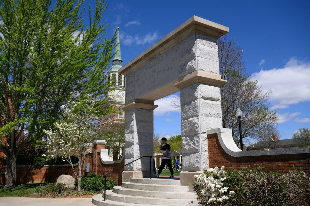 Student walking under the Arch near Hearn Plaza