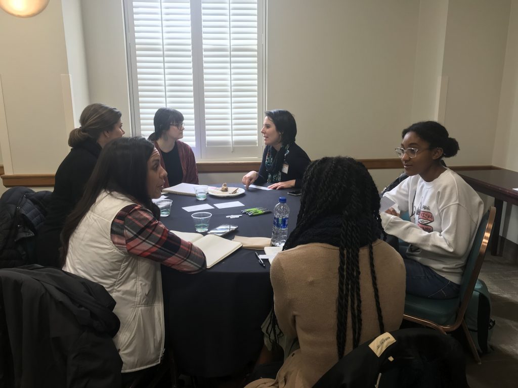 6 women at a round table actively engaged in conversation