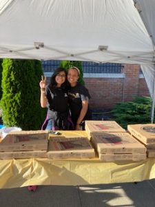Women's Center staff serving pizza and refreshments to attendees. 