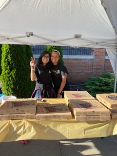 Women's Center staff serving pizza and refreshments to attendees.