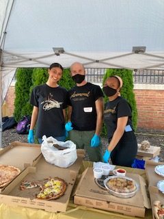 Women's Center staff serving pizza and refreshments to attendees.