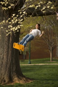 Wake Forest student relaxes on a swing on Davis Field.