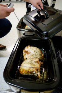 Wake Forest students cook and deliver Thanksgiving meals during the annual Turkeypalooza event held by the volunteer organization Campus Kitchen. Hailey Estes ('16) takes the finished turkey breasts out of the roasting pans.