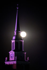 The full moon sets over the bell tower of Wait Chapel on the campus of Wake Forest University, Wednesday, October 24, 2018.