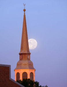 One day past full, the moon sets over the bell tower of Wait Chapel on the campus of Wake Forest University, Thursday, October 25, 2018.