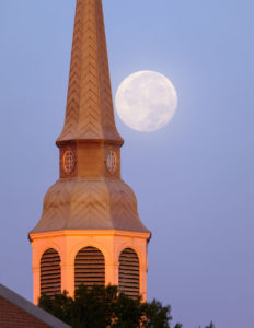One day past full, the moon sets over the bell tower of Wait Chapel on the campus of Wake Forest University, Thursday, October 25, 2018.