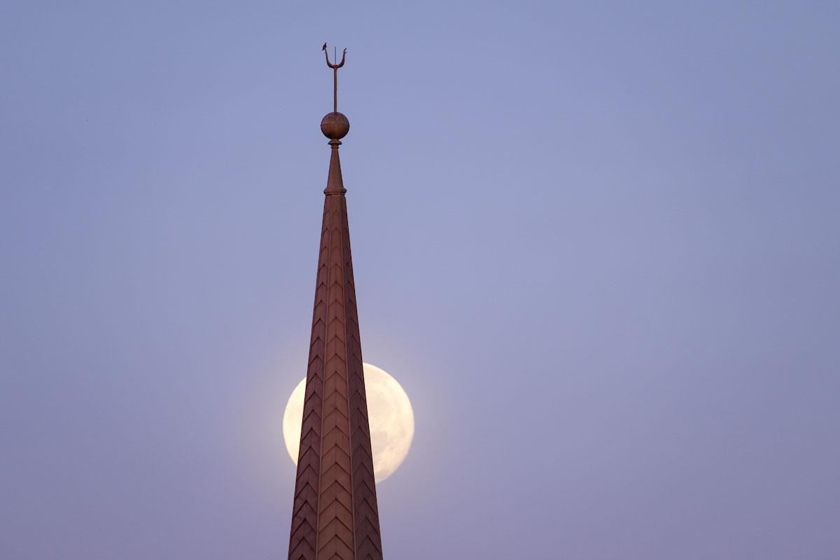 One day past full, the moon sets over the bell tower of Wait Chapel on the campus of Wake Forest University, Thursday, October 25, 2018.