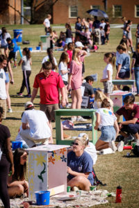 Wake Forest students paint desks for local elementary school students at the annual volunteer service project DESK, on Poteat Field on Wednesday, April 10, 2019.