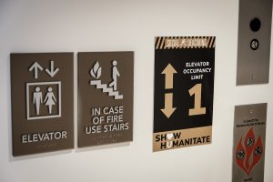 “Show Humanitate” signage detailing appropriate behaviors during the coronavirus pandemic are installed on campus buildings, on the campus of Wake Forest University, Wednesday, August 12, 2020.. The phrase is a play on the university motto, Pro Humanitate (For Humanity.) This sign gives the capacity of an elevator in Farrell Hall.