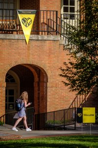 Wake Forest students walk past the Benson University Center on Thursday, September 3, 2020. Signs showing the university operating status of Yellow, indicating that coronavirus is well controlled on campus.