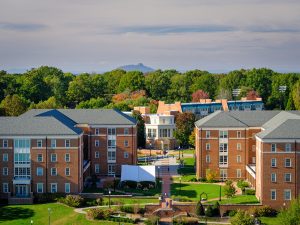 An aerial view of North Campus upperclass residence halls, Magnolia, Dogwood, and Polo Halls, with Pilot Mountain in the distance, on the campus of Wake Forest University, Monday, October 19, 2020.