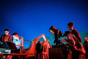 Wake Forest students learn to calculate the diameter of celestial objects using a telescope and basic trigonometry, in their astronomy class in Olin Hall on the evening of Thursday, March 28, 2019. Nathan Shepherd ('22) and Michelle MacDougald ('22) look through their telescope. The observation deck is bathed in red light to maintain the students' night vision.