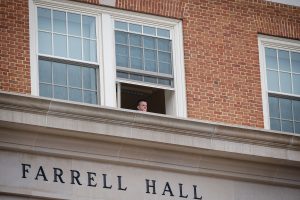 Someone watches from a Farrell Hall window as the Blackhawks arrive