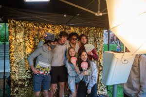 Students in photo booth with funny props before Wakechella