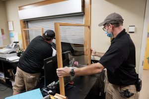 Wake Forest facilities crew members Ben Venable and Jay Huffman install clear acrylic shields in public spaces in the Benson Center during the COVID-19 pandemic, on Monday, July 20, 2020. They made the frames from repurposed bunk bed frames from residence hall renovations.