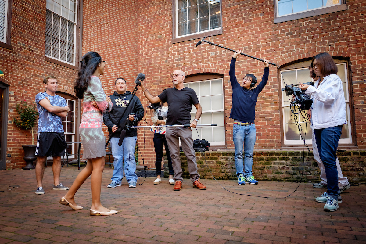 Documentary film professor Peter Gilbert teaches his first year class the basics of camera and mic setup in the new space on Brookstown Road in Winston-Salem on Wednesday, October 14, 2015.