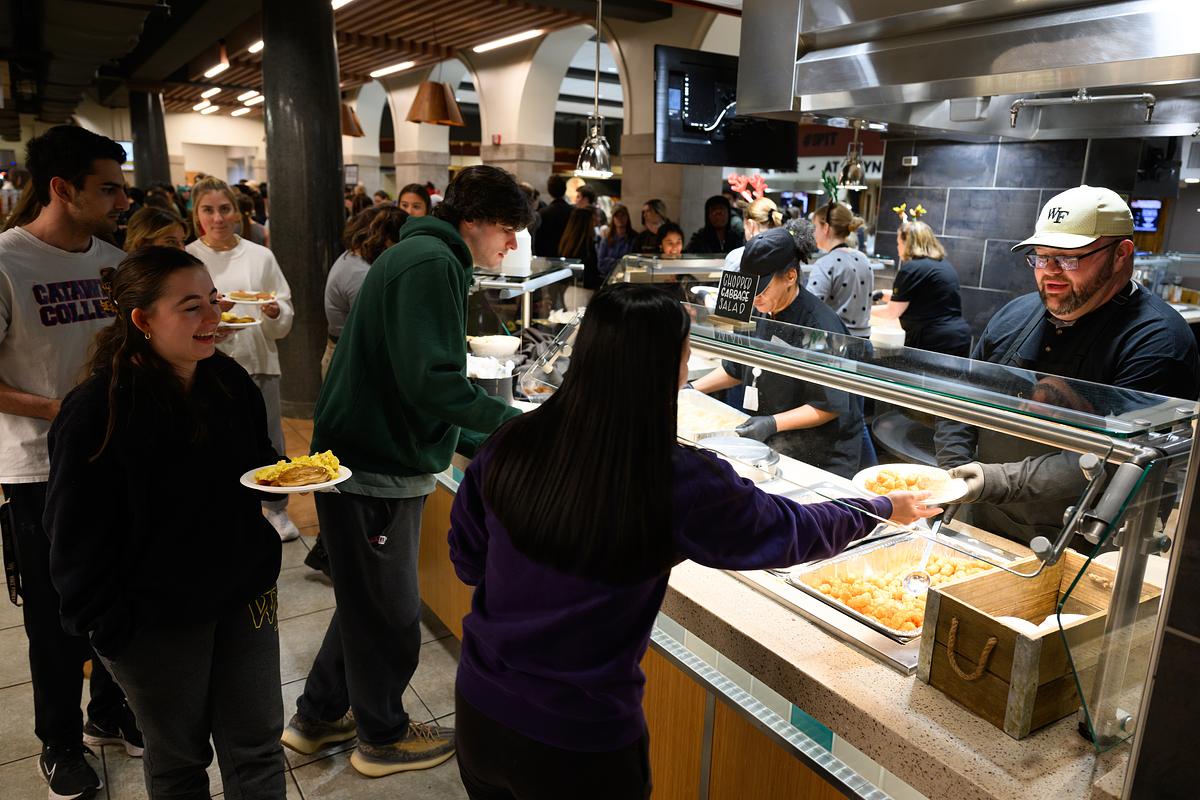 Wake Forest University students enjoy a late night breakfast served by faculty and staff before the start of exams, in the Pit on Wednesday, December 6, 2023.