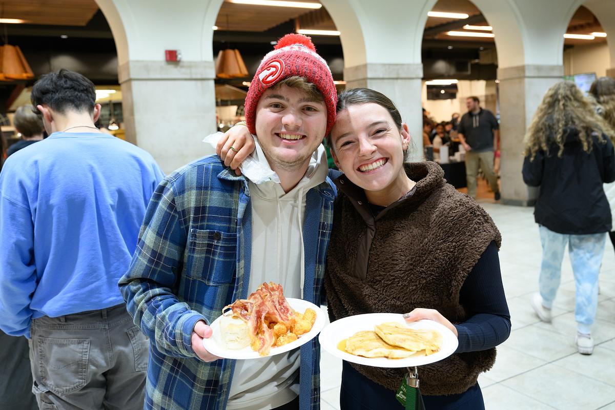 Wake Forest University students enjoy a late night breakfast served by faculty and staff before the start of exams, in the Pit on Wednesday, December 6, 2023.