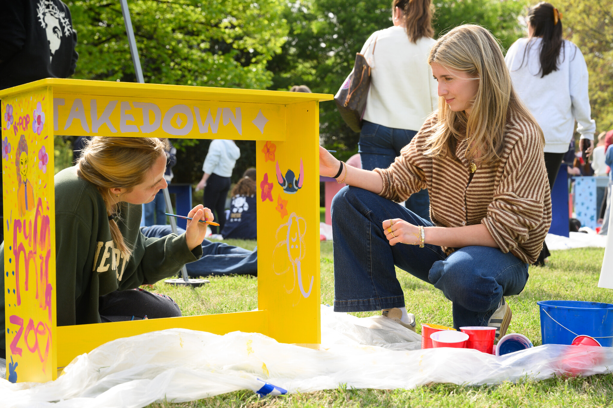 Wake Forest University students paint desks alongside local school children at Davis Field on Wednesday, April 8, 2026 as part of Discovering Education through Student Knowledge (DESK). The event brings local elementary school children to campus each spring to create inspiring, colorful study spaces for students in their homes. A longstanding campus tradition, DESK was started in 2001 in partnership with Old Town Elementary after two WFU students identified a lack of workspace in the homes of the children they were tutoring.