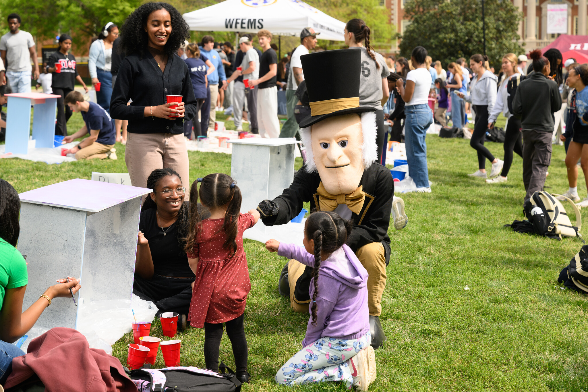 Wake Forest University students paint desks alongside local school children at Davis Field on Wednesday, April 8, 2026 as part of Discovering Education through Student Knowledge (DESK). The event brings local elementary school children to campus each spring to create inspiring, colorful study spaces for students in their homes. A longstanding campus tradition, DESK was started in 2001 in partnership with Old Town Elementary after two WFU students identified a lack of workspace in the homes of the children they were tutoring.