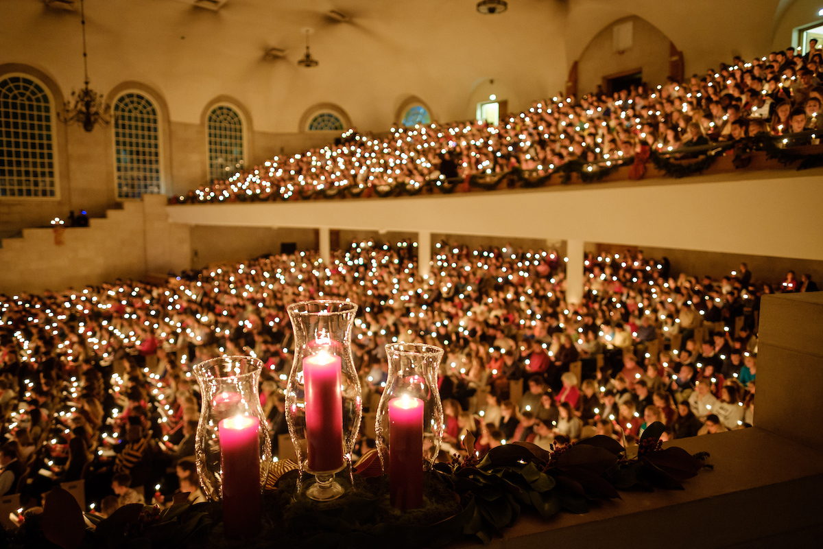 crowded wait chapel with visitors holding lighted candles
