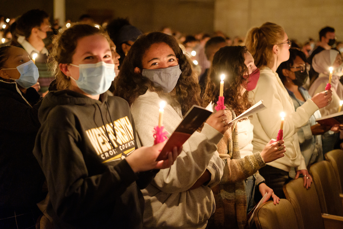 students wearing masks hold candles in Wait Chapel