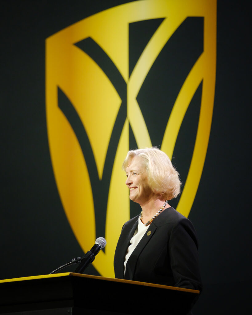 President Wente speaks in front of the Wake Forest shield logo