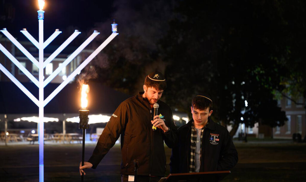 Students at a podium with the menorah