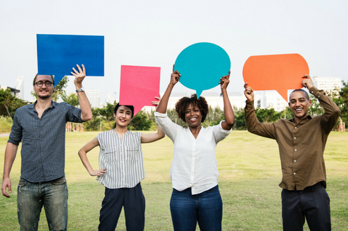 Four people holding thought bubble signs
