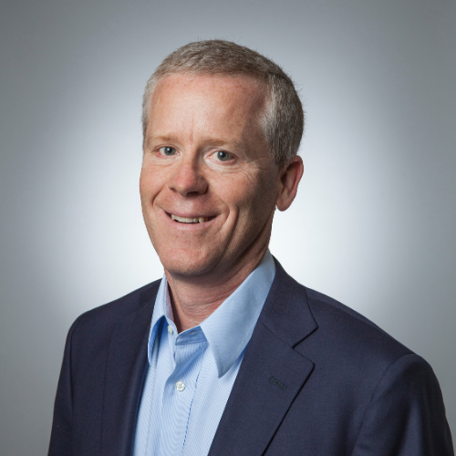 Headshot of Brad McRae, he is wearing a blue shirt, suit jacket and a smile