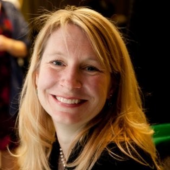 Headshot of Carrie Henderson, she has blonde hair and a big smile