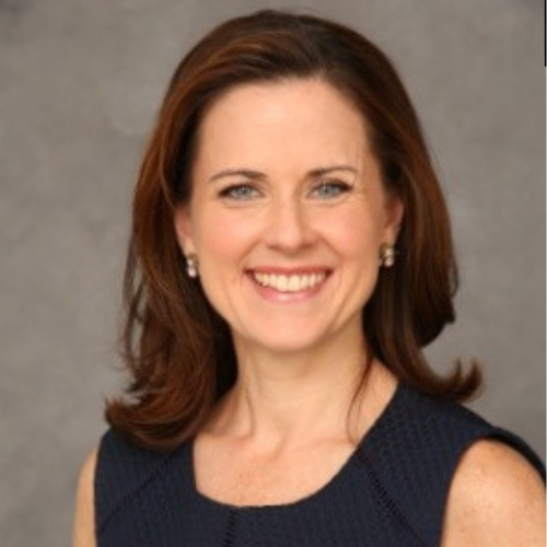 Headshot of Kate Maloney, she is wearing black dress and a big smile