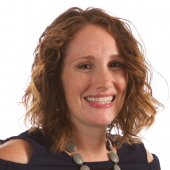 Headshot of Lindsey Von Thron, she has curly short brown hair and a big smile