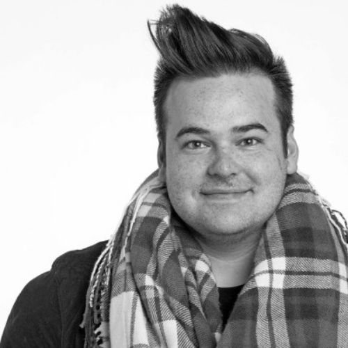 Headshot of Zach Garbiso, he is wearing a big scarf