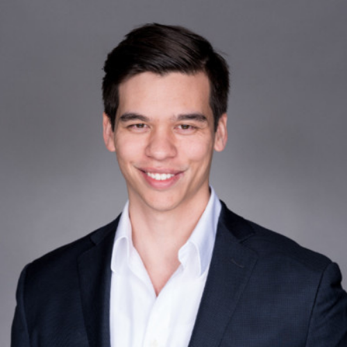 Headshot of Eric Slotsve, he has brown hair and is wearing a suit jacket and white shirt