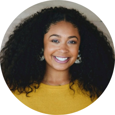 Headshot of Sydnie Williams, she is wearing a bright yellow shirt, natural hair and a big smile