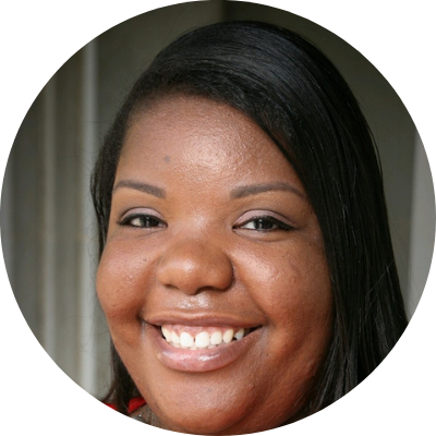 Headshot of Tiffany Newsome. She has dark hair and skin, and is wearing a smile.