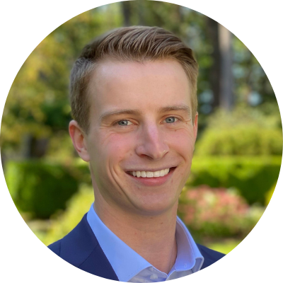 Headshot of Jason Hooker, white male with blonde hair, wearing a blue shirt and suit jacket and a big smile