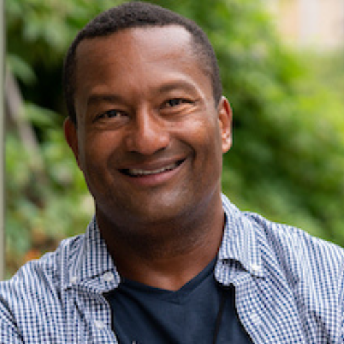 Headshot of Brian Johnson. He is wearing a blue shirt and a big smile.