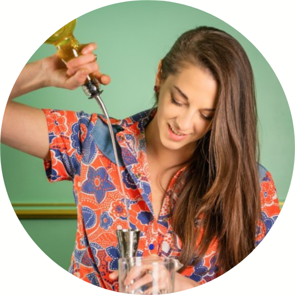 Head shot photo of woman in floral shirt pouring a drink into a glass