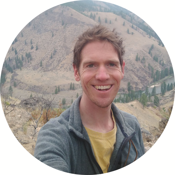 Head shot photo of Ben Robb outdoors with mountains behind him