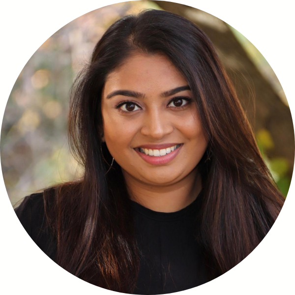 Head shot photo of Laya Mohan, woman in black shirt with dark hair and smiling