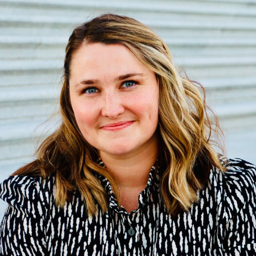headshot of Margaret Mulkerrin. She has short, wavy hair and she is wearing a black and white spotted shirt. 